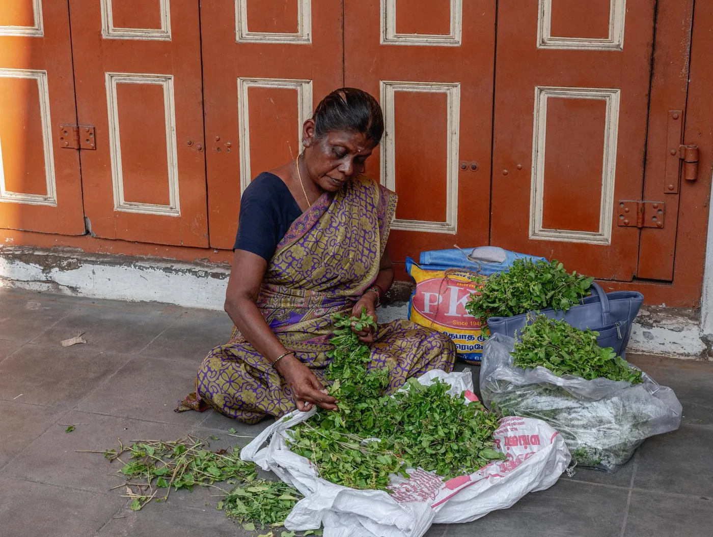 A woman sorting fresh herbs by hand